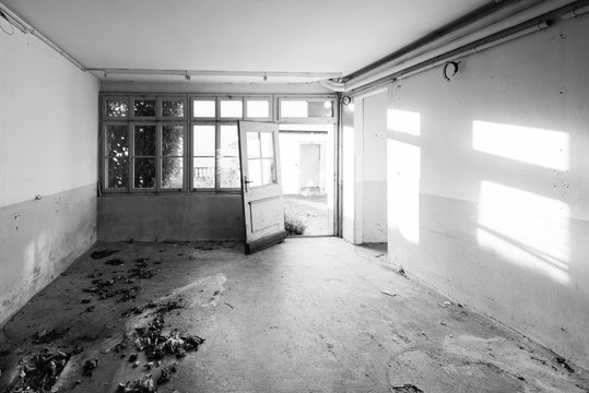 House that no longer exists. Old abandoned house. The room is destroyed, the walls are broken, trash on the floor, chaos. Selective focus. Black and White.