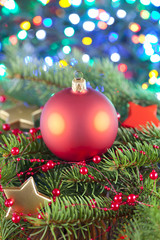 Christmas ball on spruce branch and lighting background