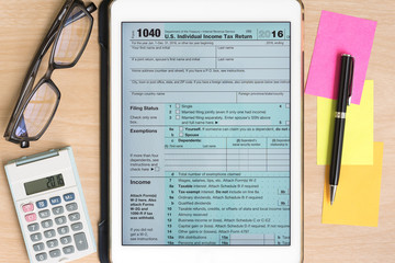 US Tax form 1040 in tablet with calculator and pen