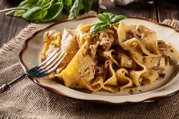 Pappardelle pasta with prosciutto and cheese sauce on a plate