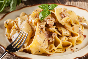 Pappardelle pasta with prosciutto and cheese sauce on a plate