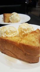 Toast with two scoop of vanilla ice-cream on white plate