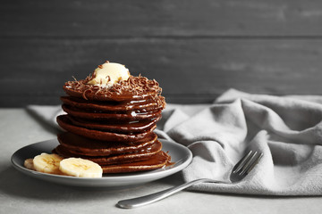 Tasty pancakes with banana and chocolate sauce on plate