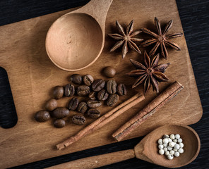 set of wooden utensils with star anise pepper cinnamon isolated on dark background
