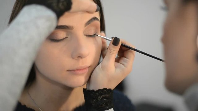 makeup artist makes models eye makeup