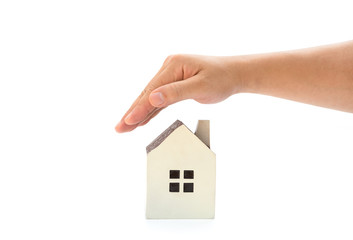 Fototapeta na wymiar right hand covering a small family house with clipping path, home insurance concept or representing home ownership