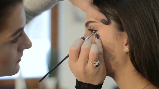 makeup artist makes models eye makeup, slow motion