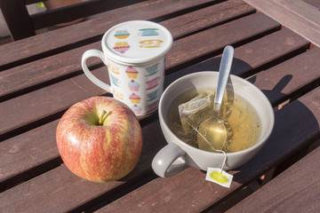 Cup of tea with apple, breakfast in the garden