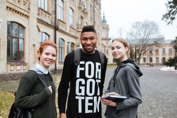 Students with books and backpacks standing at the university campus