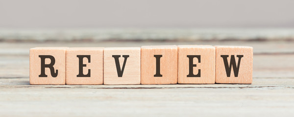 Word review written with wood cubes on table