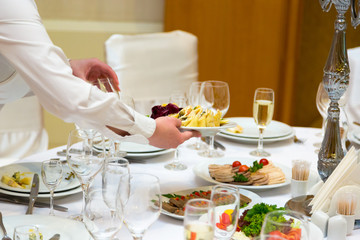 The waiter prepares for a banquet table