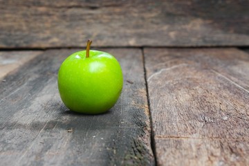 Green apple on wooden table  background