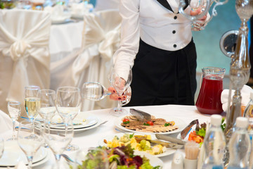 The waiter prepares for a banquet table