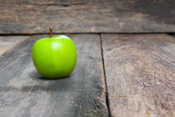 Green apple on wooden table  background