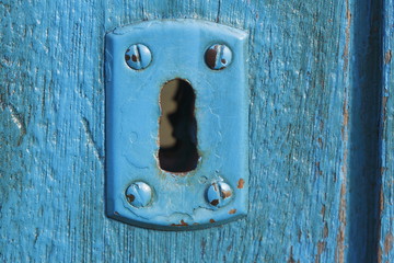 Blaues Türschloss aus Metall auf alter blauer Holztür