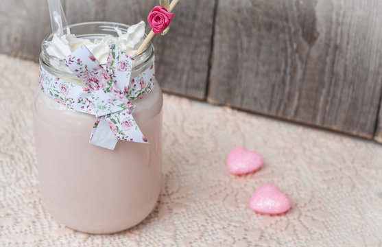 Pink Raspberry milkshake on Valentine's Day with hearts and whipped cream.