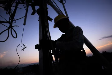Silhouette of Technician working on communication towers in the dusk © somrerk