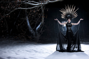 Mystisch magische Burlesque Tänzerin bei Nacht im winterlichen Wald