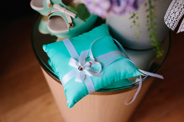 A couple of gold rings on turquoise cushion