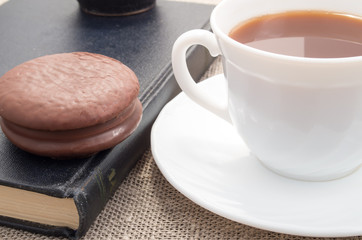 View close-up on white cup with cocoa and chocolate cake