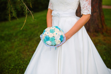Blue aquamarine turquoise rose bouquet in hands of bride