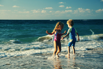 kids playing on the beach at sunset