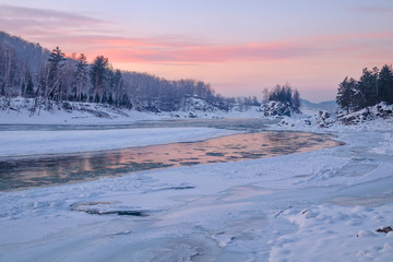 Fototapeta na wymiar Frozen river/Reflection of the sunset sky in a frozen river. Katun River, Mountain Altai, Siberia, Russia