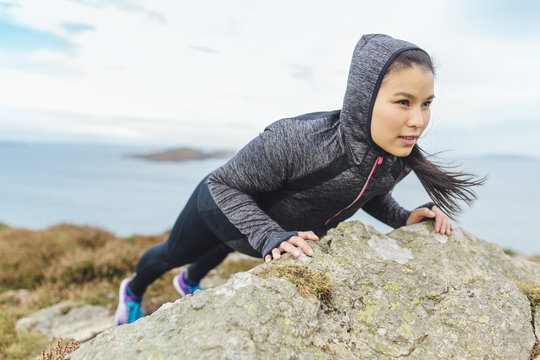 Ireland, Howth, woman exercising at cliff coast