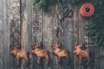 Row of four Elk-shaped Christmas cookies on dark wood