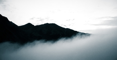 A beautiful monochromatic mountain view with rising clouds