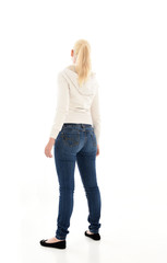 Obraz premium Full length portrait of a pretty girl wearing a casual white hoody and blue jeans. standing pose isolated against a white background.