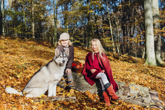 Hansel and Gretel, Boy and girl sitting in forest on a tree trunk