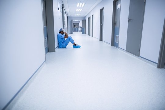 Sad surgeon sitting on a floor