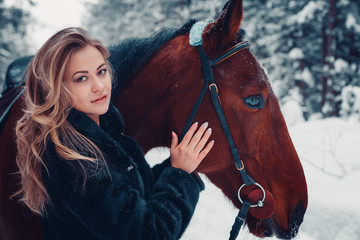portrait of a beautiful girl in black coat, horse, winter