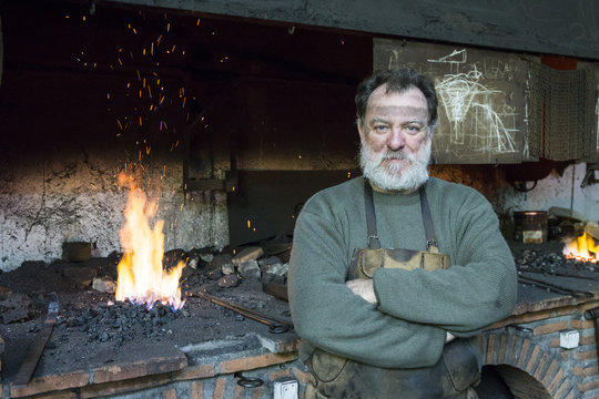 Portrait of confident blacksmith in his workshop