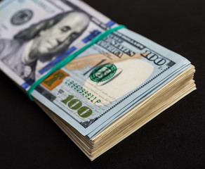 Money roll with US dollars. Selective focus.