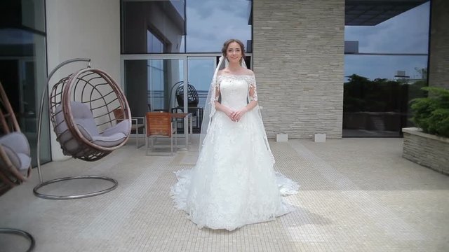 Dream wedding. Beautiful bride waiting for the groom. Bride smiling with happiness. Wedding Celebration. Bright Sunny Day.