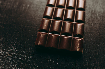 chocolate on wooden table on dark background