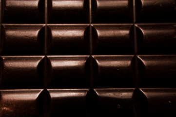 chocolate on wooden table on dark background