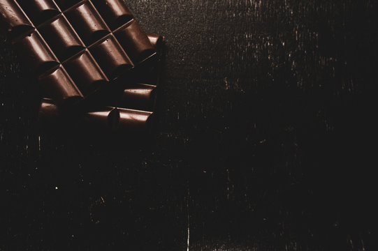chocolate on wooden table on dark background