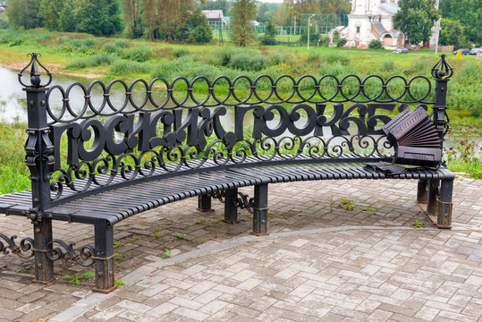Forged bench with the inscription "Sit, pookaem" on the embankment rivers and view of the Church Candlemas of the Lord