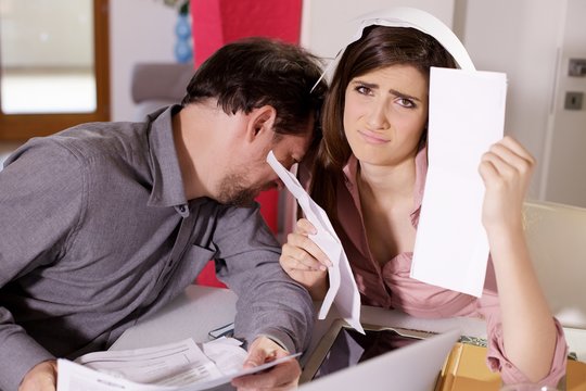 desperate husband and wife having trouble with taxes and bills to pay