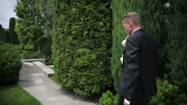 The groom is going to the wedding ceremony with a bouquet