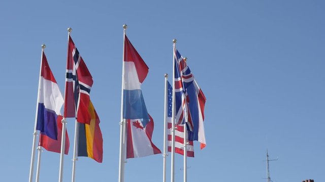 Slow motion of different nations symbols waving on white poles 1920X1080 HD footage - American and European flags mixed on the wind 1080p FullHD video