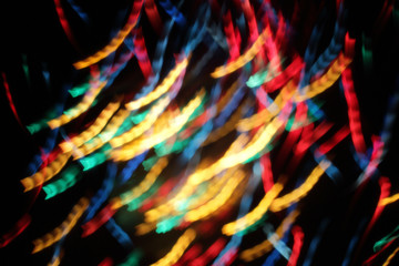 enchanting holiday atmosphere/ blurred colored lights garlands and streamers 