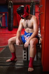Tired boxer sitting in locker room
