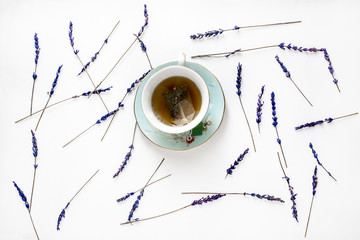 Creative composition with cup with lavender tea and lavender flowers on white background