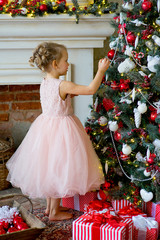little girl decorating Christmas tree at home