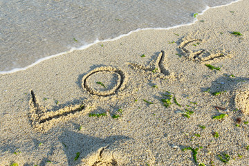 Sea beach sand waves and drawings of sun, love and heart