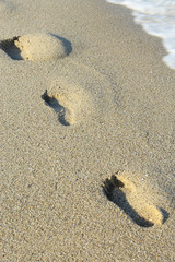 Footprints on Sea beach sand waves